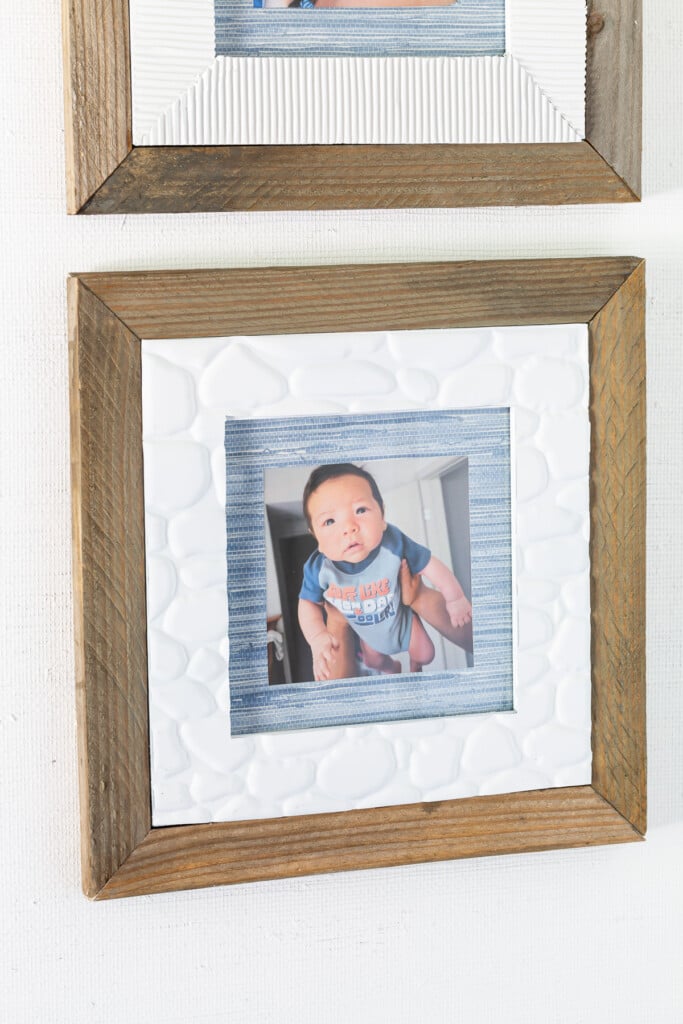 Scrap wood framed thrift store frame makeover idea that also uses wallpaper scraps and faux stone adhesive tile from the dollar tree.