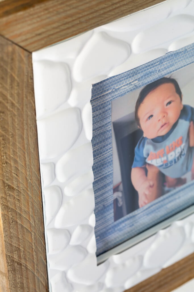 Thrift store picture frame makeover. Textured stone adhesive tiles from the dollar store used to decorate a thrift store frame.