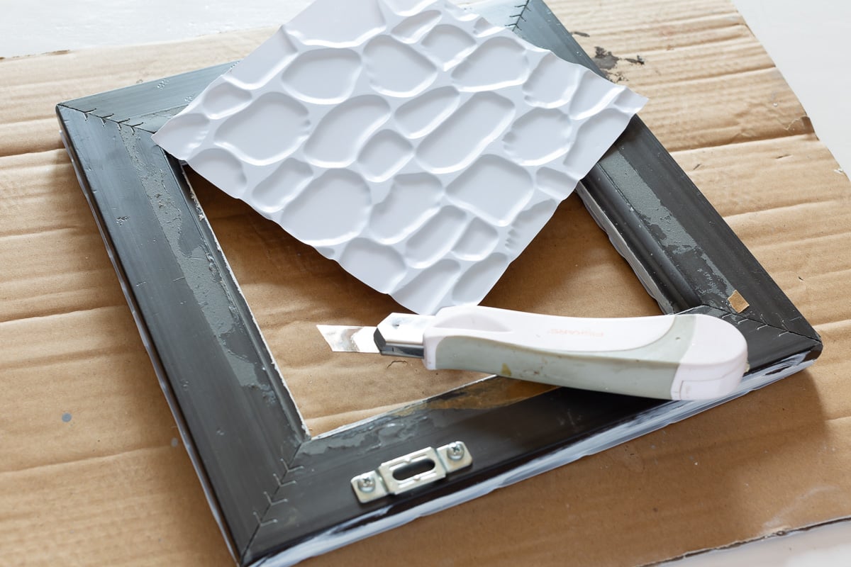 how to decorate a thrift store photo frame with dollar store adhesive tile.