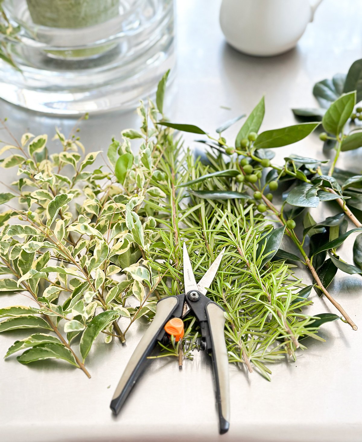 herbs and shrub clippings from a yard needed to make a summer table centerpiece candle vase.