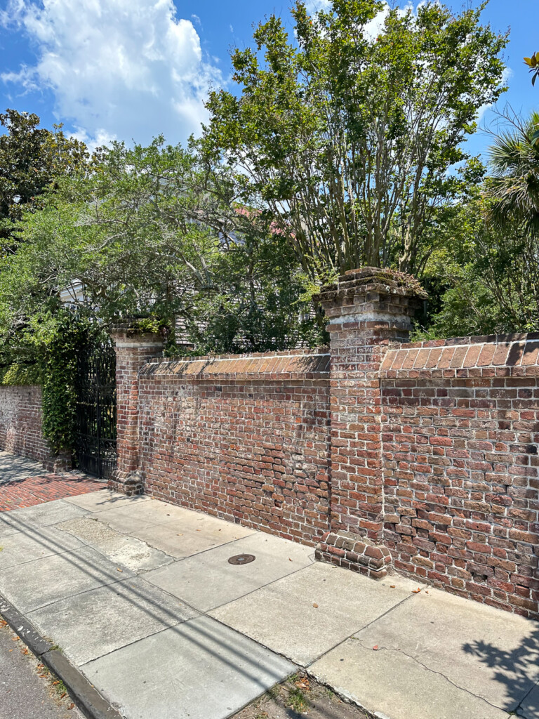ornate brick wall along sidewalk in Charleston, SC