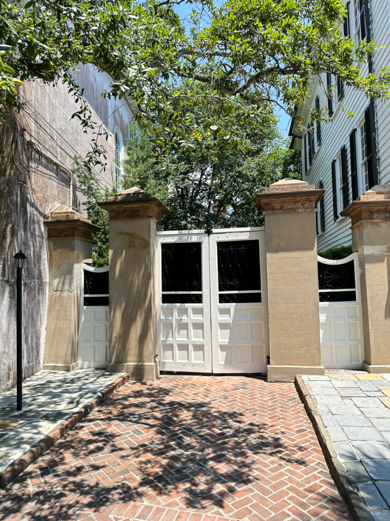 White wood driveway door flanked by stucco square columns.
