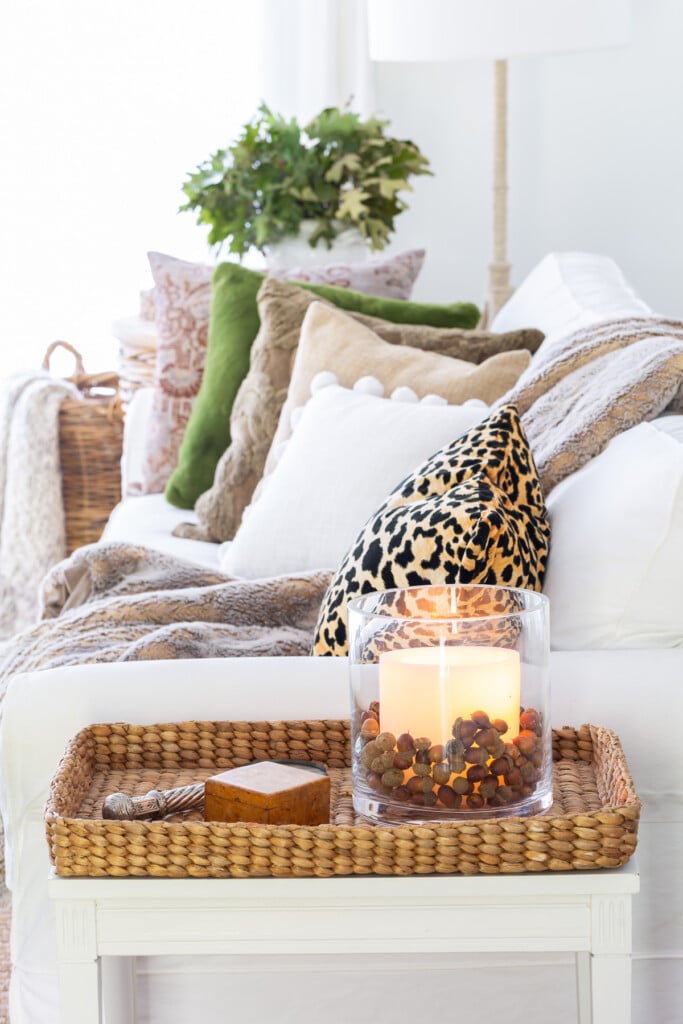 Side view of a white sofa with fall colored throw pillows on it.