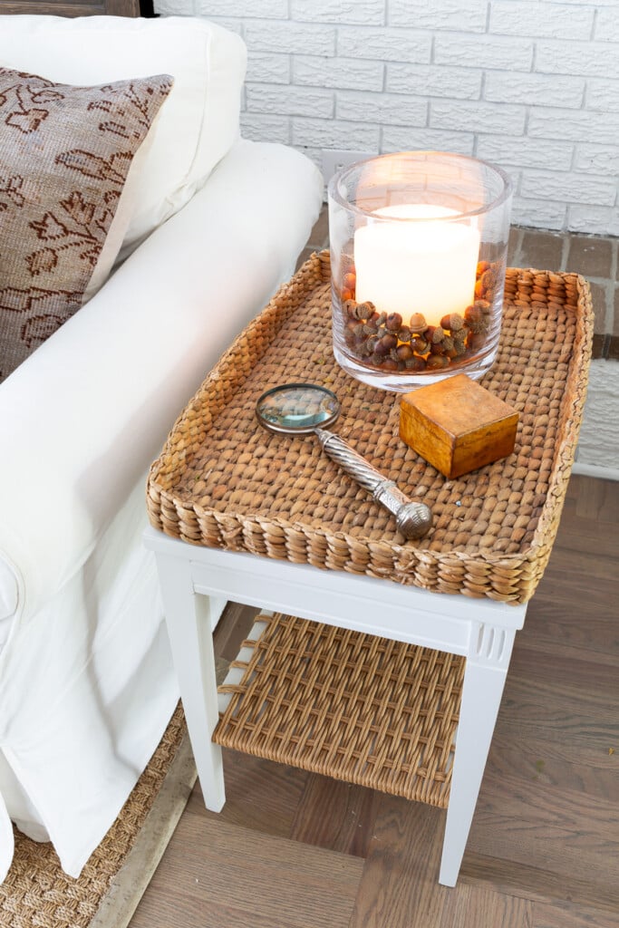 Woven tray side table in living room decorated for fall.