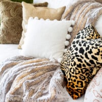 A collection of textured and patterned pillows on a sofa in a fall decorated living room.