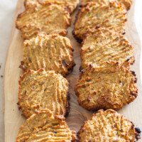 10 healthy cookies cooling on a wood board.