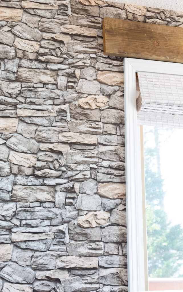 Close up of faux stone peel and stick wallpaper on a wall in a kitchen.