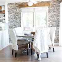 Small kitchen dining area decorated in neutral colors with faux stone wallpaper on wall.