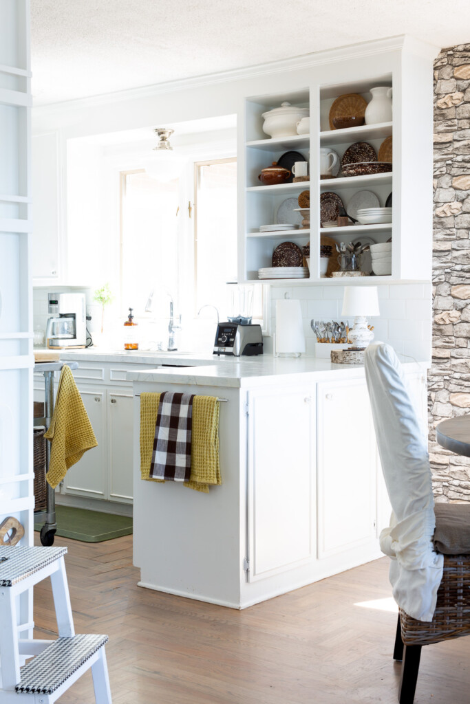 white kitchen that is decorated in a simple way for fall uses browns mixed with white and yellow.
