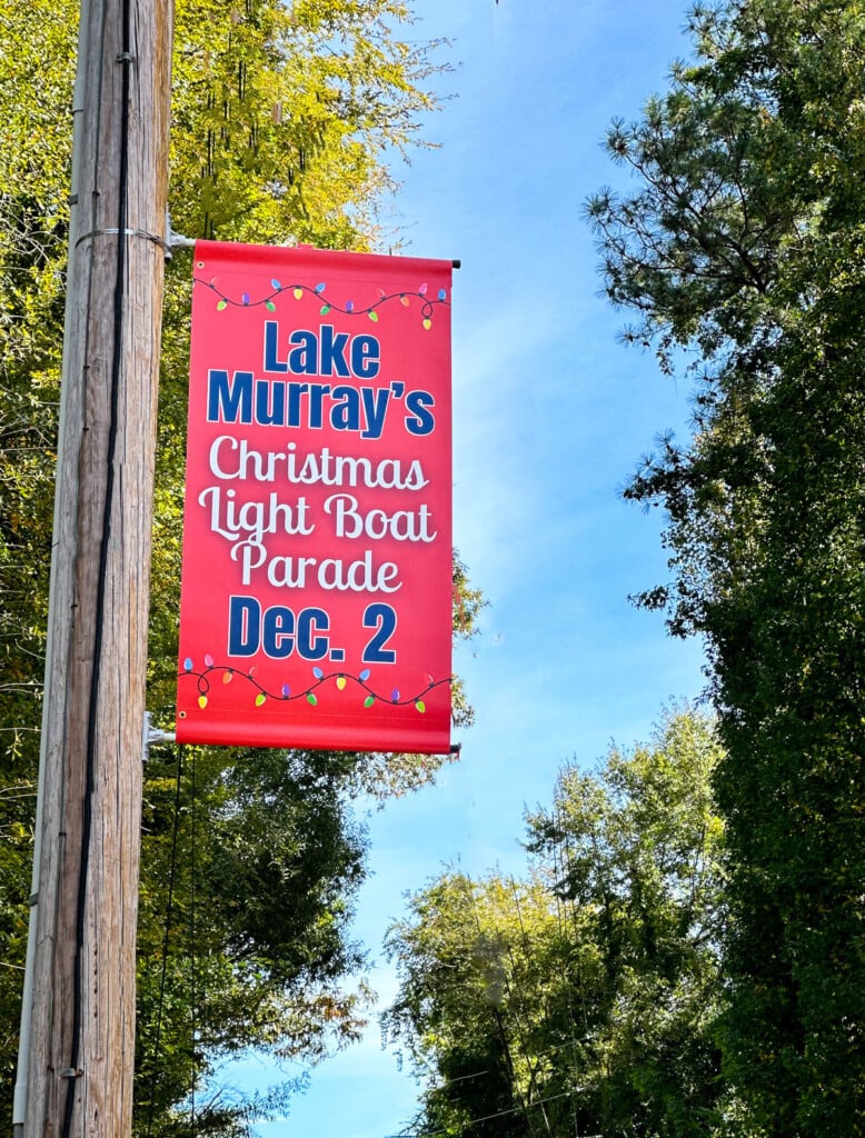 A sign that Christmas is coming. A sign on a town's street lamp pole that says Lake Murray's Christmas Light Boat Parade Dec. 2