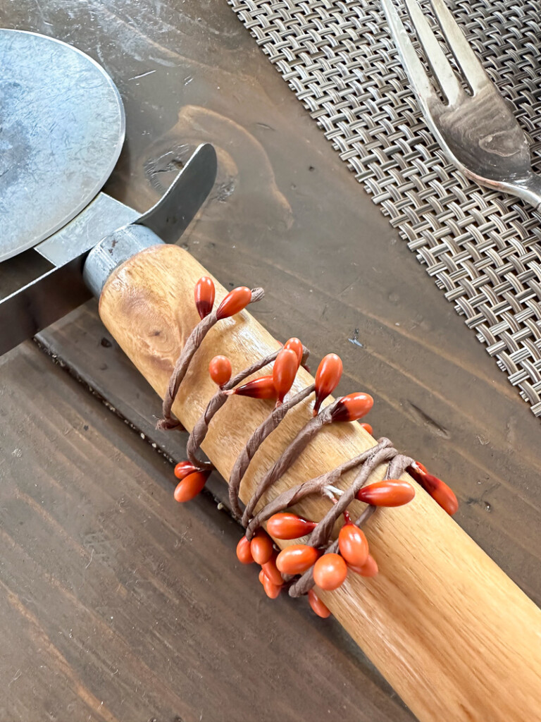 fall berries on wire wrapped around a wood handle to make a fall dinner napkin ring.