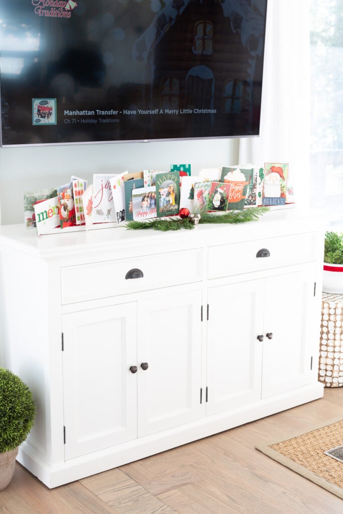 DIY holiday greeting card stand on a sideboard under a wall mounted TV.