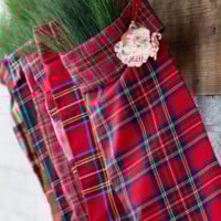 DIY Fabric red plaid handmade stockings hanging from a wood mantel.