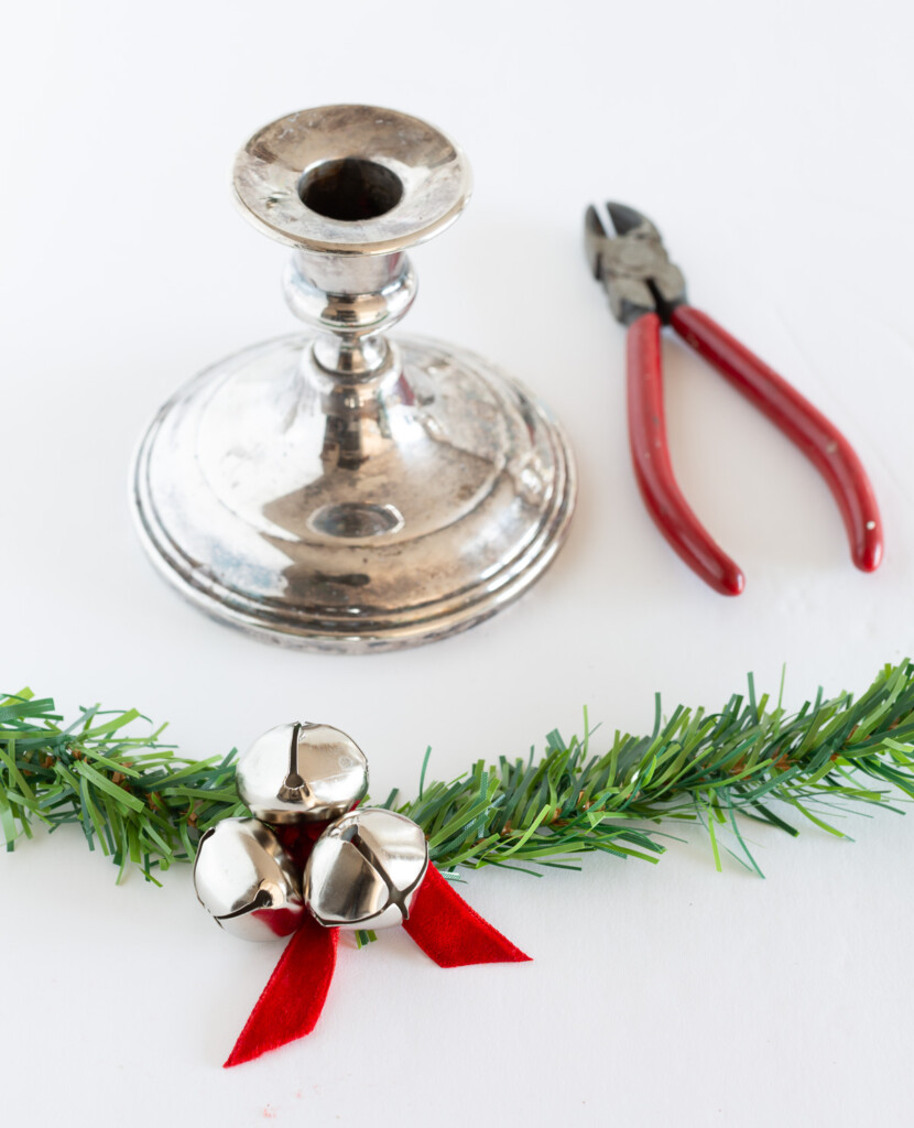 How to make a taper candle ring to decorate a home for Christmas using a garland tie and jingle bells.