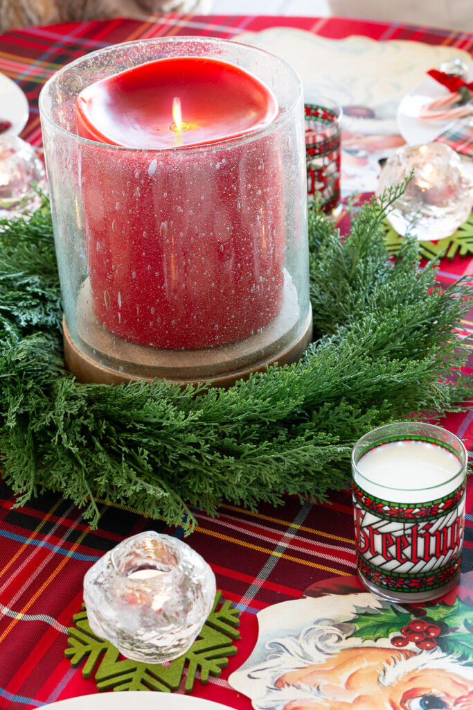 6 x 6 large battery operated red candle with cedar wreath surrounding it on a round