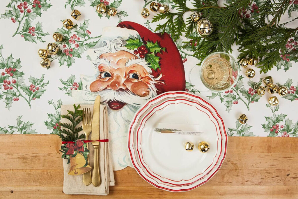 Vintage Santa face paper placemat on table with holly pattern tablecloth