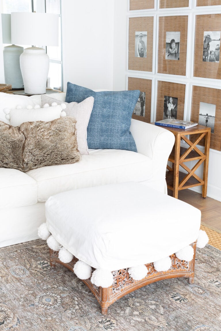Corner of living room decorated in blue and white and fur throws.