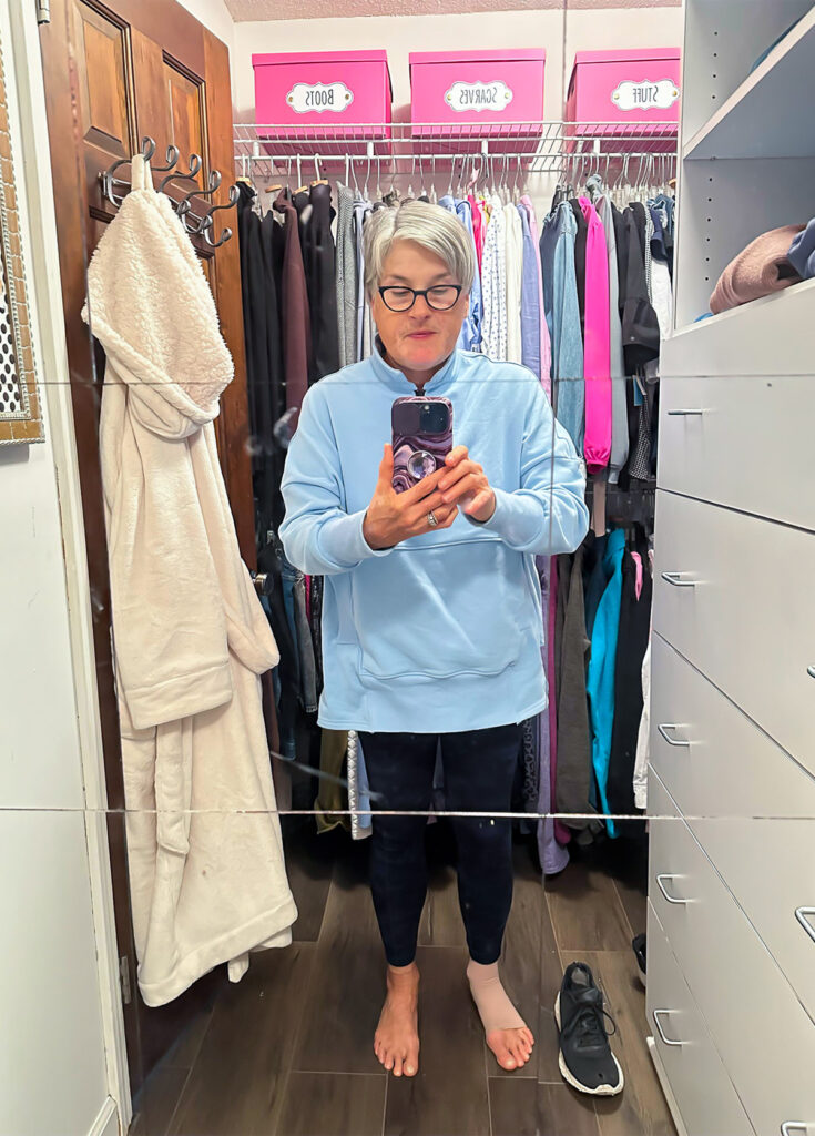 Diane in a sky blue oversized half zip pullover.