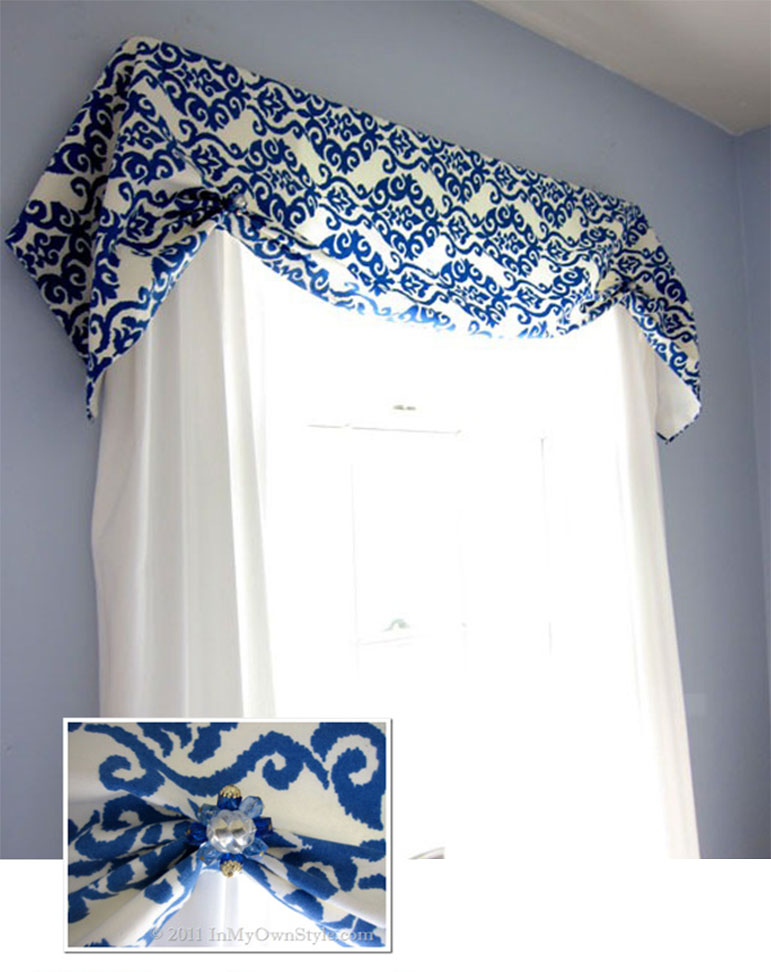 blue and white window valance with old jewelry used as decorative accents.