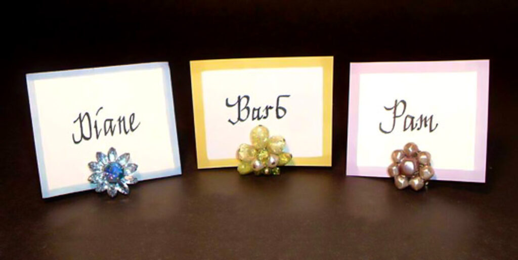 3 place cards using vintage clip on earrings as place card holders.