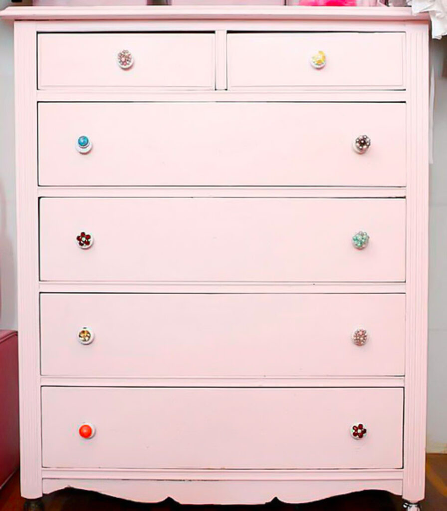 pink chest of drawers with vintage clip on earrings as drawer pulls.