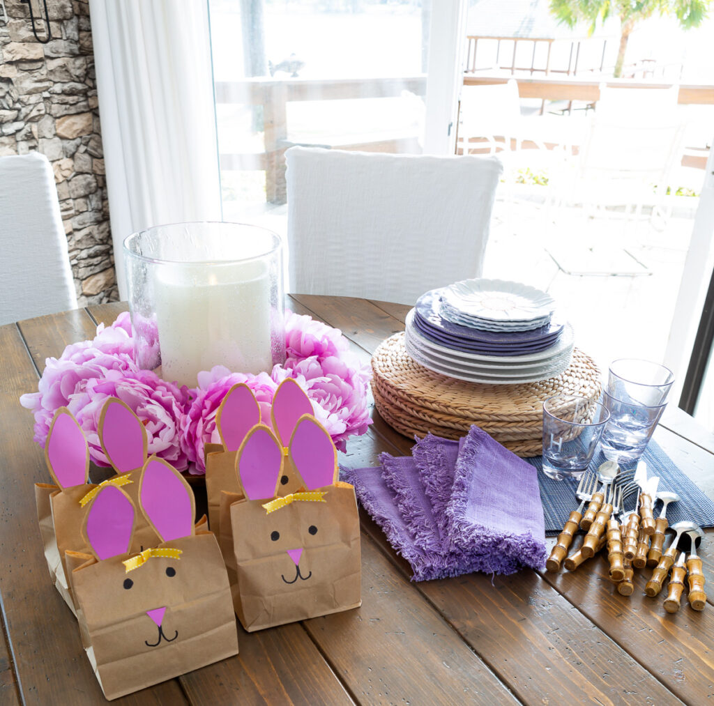 Dinnerware, napkins and Easter goodie bags all ready to be set into a festive Easter table setting.