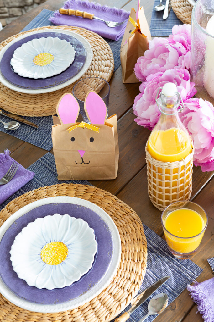 Causal Easter table setting with rattan, purple, white and blue accents.