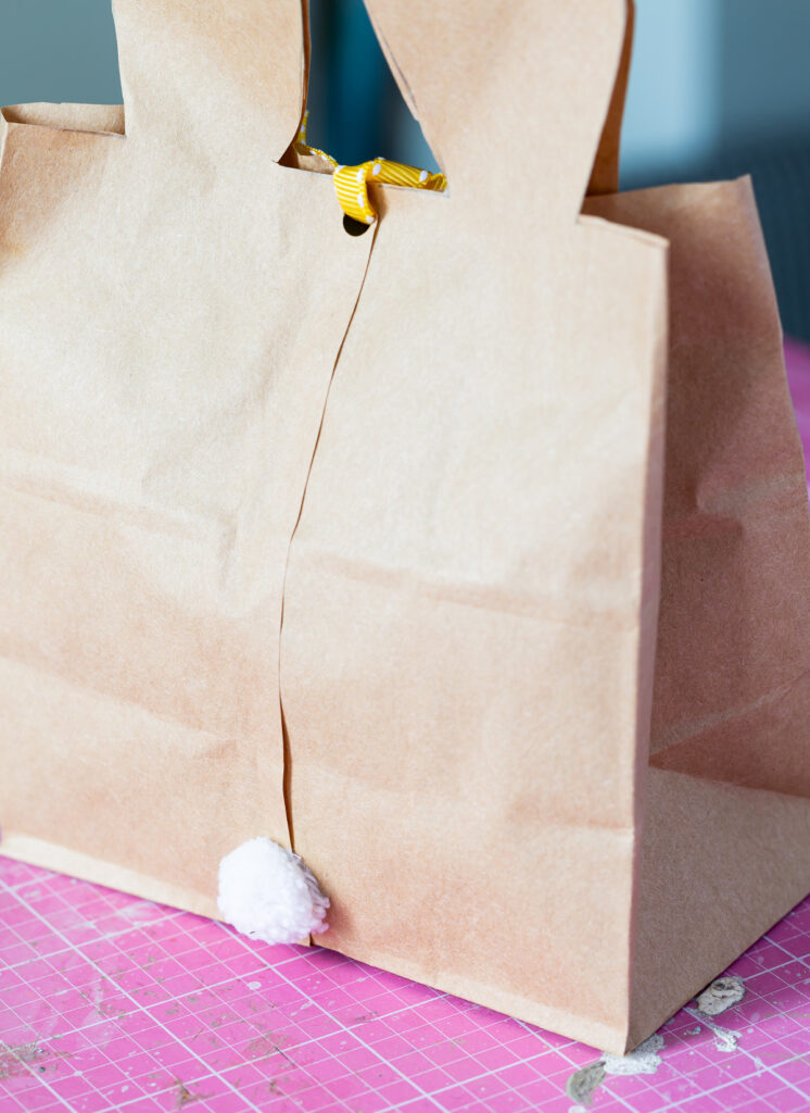 Back of a DIY Easter Bunny bag with a white pom pom for a tail.