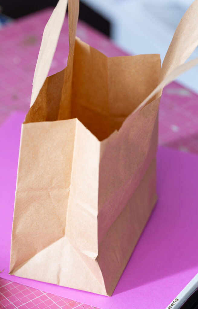 Cut excess paper from sides of brown lunch bag.