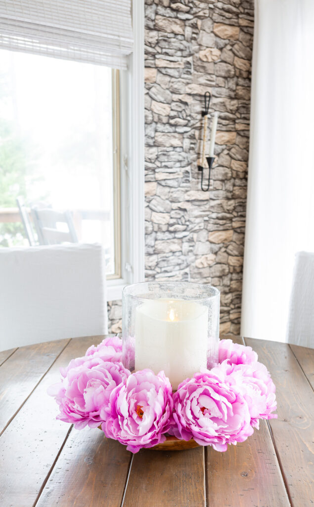 Pink floral table centerpiece on wood table.