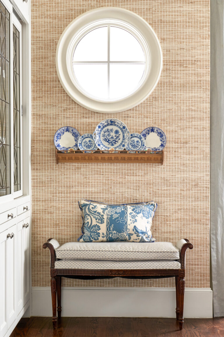 Edmondson-Ave-designer-Sara-Johnson decorated corner of a room with blue and white plates against beige woven wallpaper.