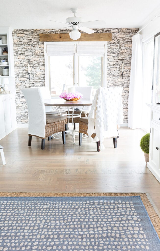 Blue rug in living room looking into a dining area in a kitchen.