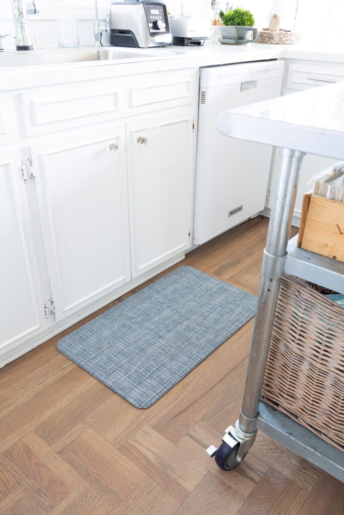 Lucky Brand wellness mat in blue weave in front of a kitchen sink.