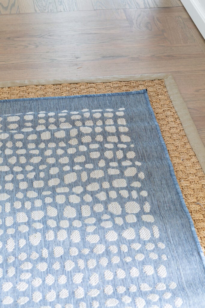 two area rugs layered one on top of the other on a hardwood floor.
