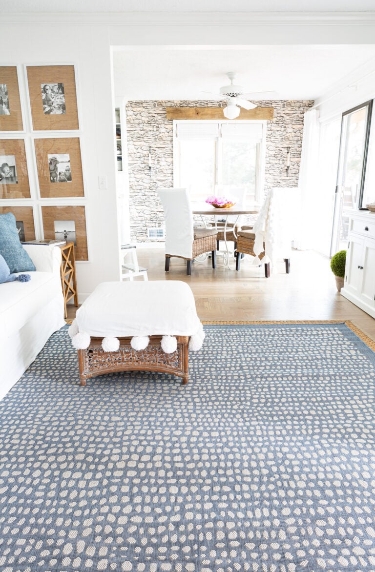 blue and white rug in a living room looking into a dining room.