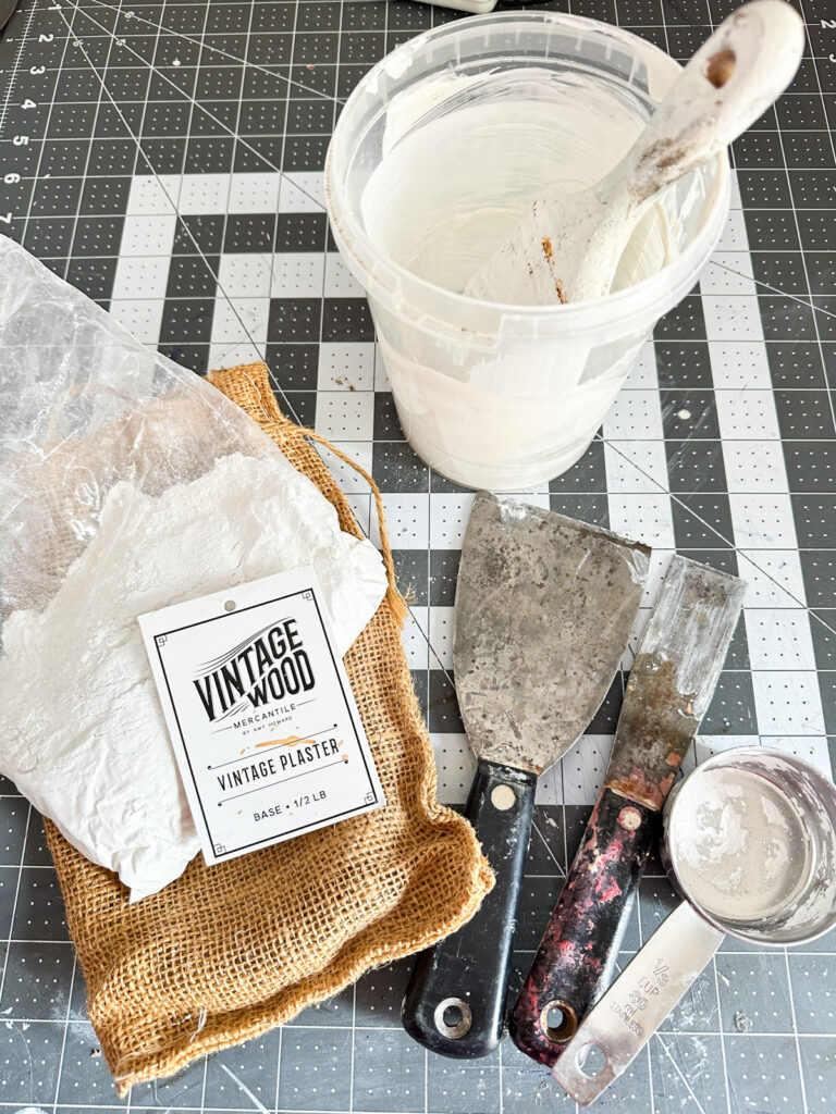 Vintage Wood in a burlap bag with paint tools on worktable.