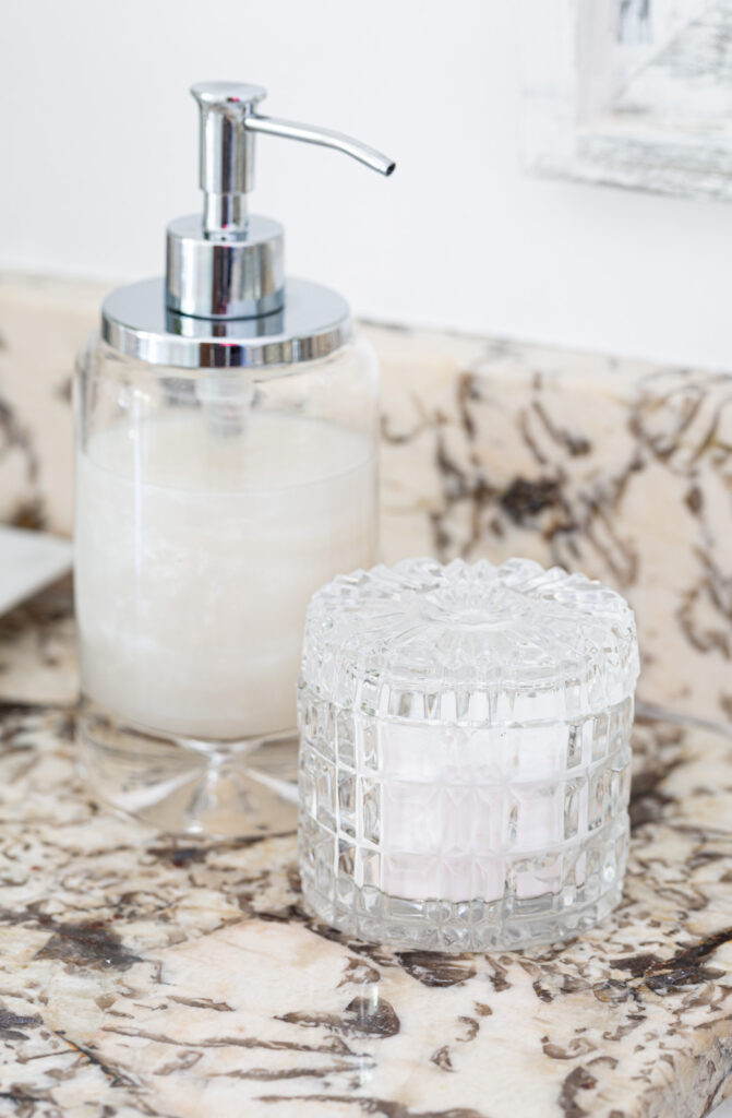 glass soap dispenser and cut crystal jar on bathroom cabinet.