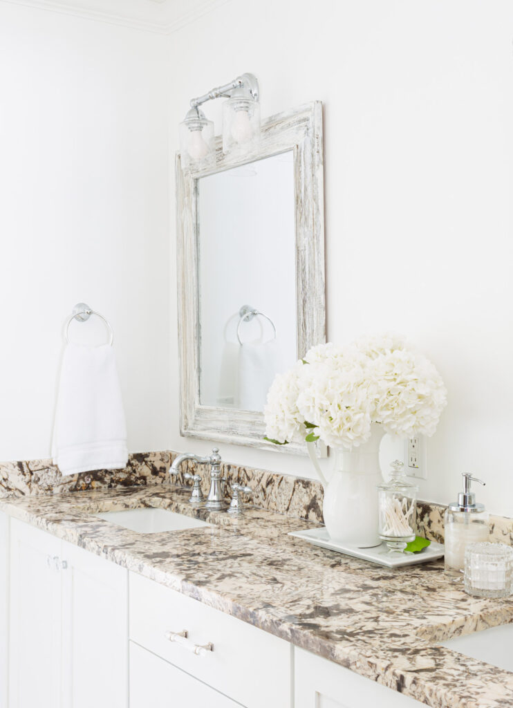 white flowers in white tray on bathroom sink vanity counter.