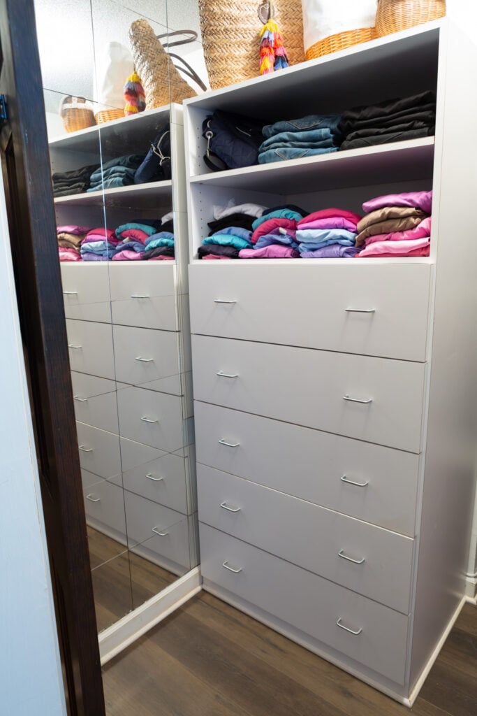 Clothes closet drawers and shelving unit in closet after getting cleaned out and reorganized.