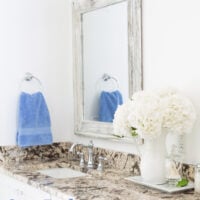 On a budget Bathroom makeover DIY white/neutral after with a color pop of sky blue.