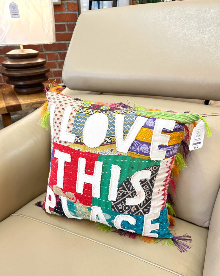 pillow that says I love this place placed on a chair