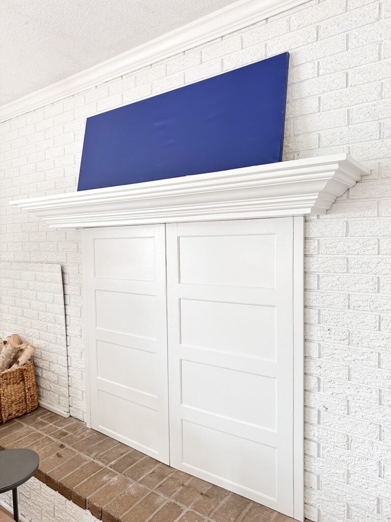 side view of a white brick fireplace wall and mantel without anything on it.