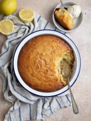 Lemon elderflower almond pudding in a round dish with some in a small bowl with ice cream.