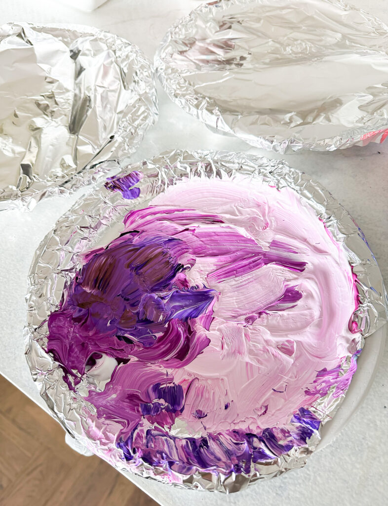 DIY Acrylic paint palette made using a paper plate lined with foil.