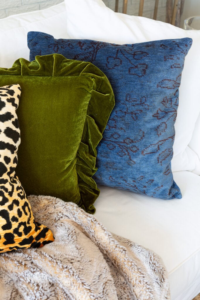 Fall colored throw pillows lined up on a white sofa. Last one was dyed blue with Rit Dye.