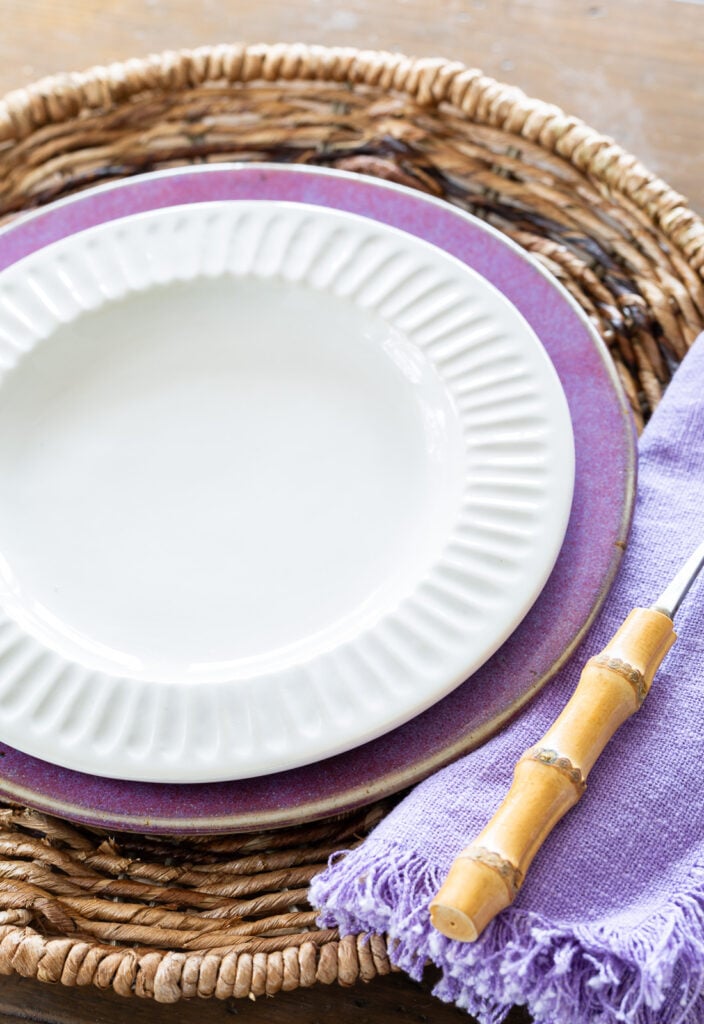 white ridged dinner plate from McGee & Co on top of a purple plate from a thrift store.