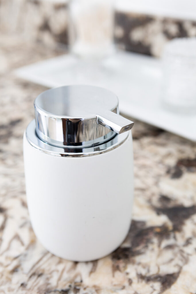 White stoneware moisturizing cream decorative pump container that looks pretty on a bathroom counter.