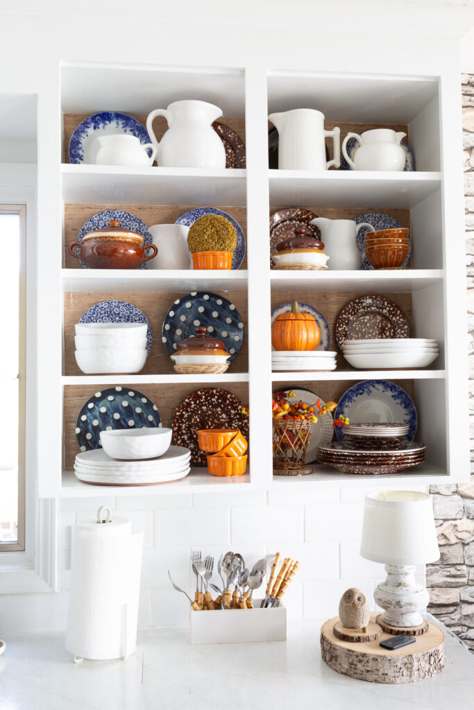 kitchen shelf styling ideas using wallpaper and your favorite dishes and serveware.