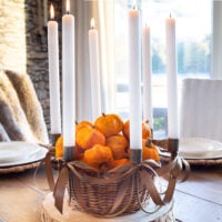 Fall table taper candle centerpiece on a wood plank table.