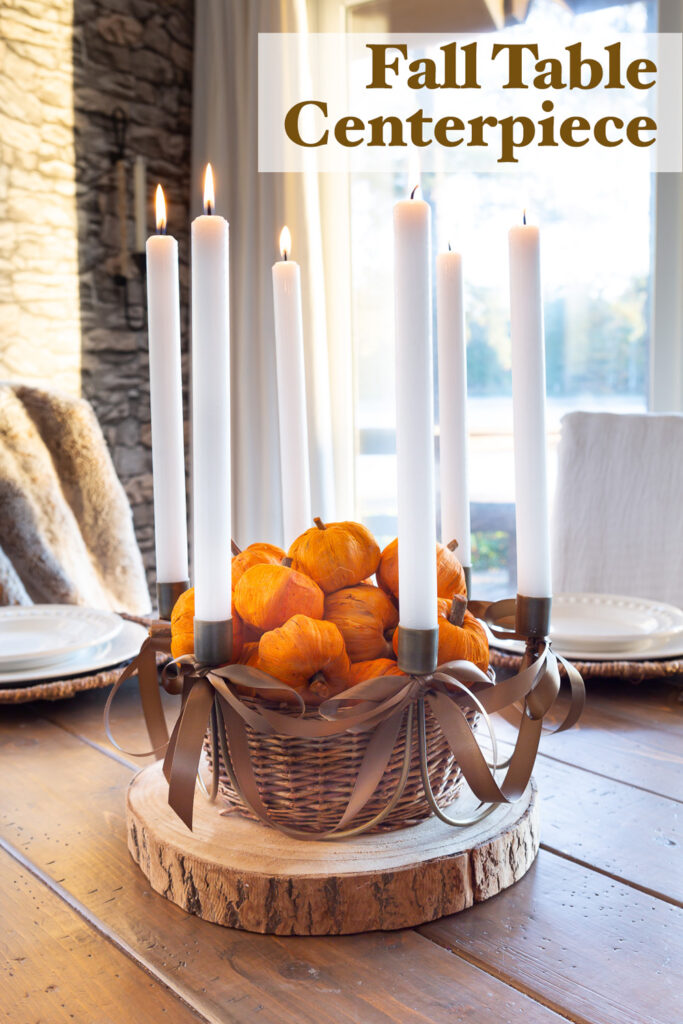 Fall table taper candle centerpiece on a wood plank table.